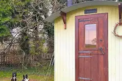 Green shepherd's hut with a wood burner and chimney