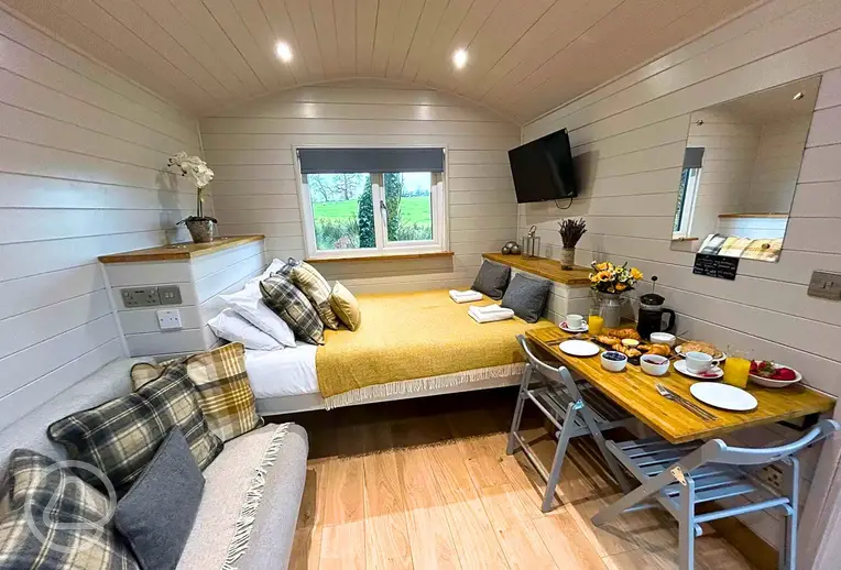 Shepherd's huts with a double bed, single sofa bed, TV and dining area