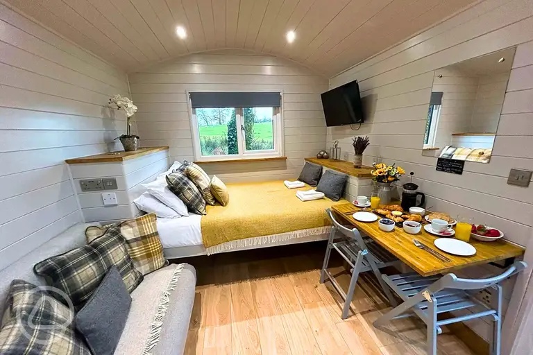 Shepherd's huts with a double bed, single sofa bed, TV and dining area