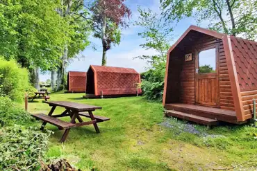 Camping pods located in a private part of the site with picnic benches
