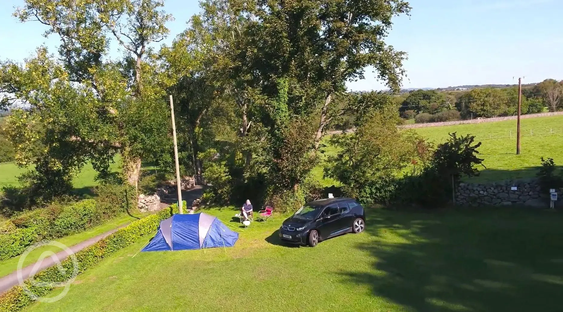 Aerial of the grass tent pitches at the edge of the campsite