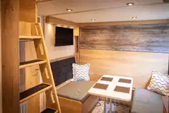 Forest glamping pod dining area with pull down double bed
