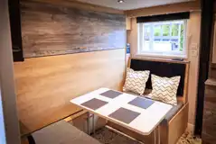 Forest glamping pod dining area with pull down double bed