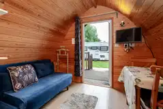 Glamping pod dining area, double sofa bed and TV (pod two) Glamping pod dining area, double sofa bed and TV (pod two)