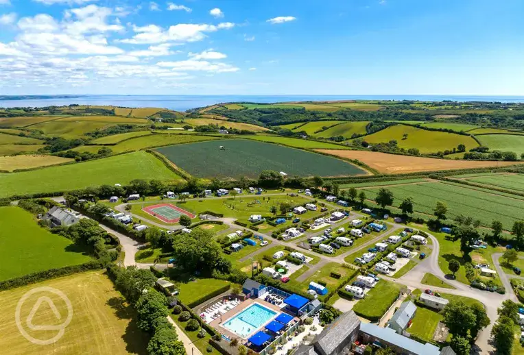 Aerial of Tregarton Park with outdoor pool, tennis courts, and sea views