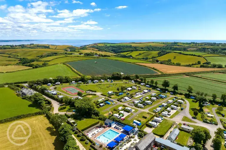 Aerial of Tregarton Park with outdoor pool, tennis courts, and sea views