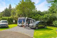 Electric hardstanding pitches with a grass area and space for a parked car
