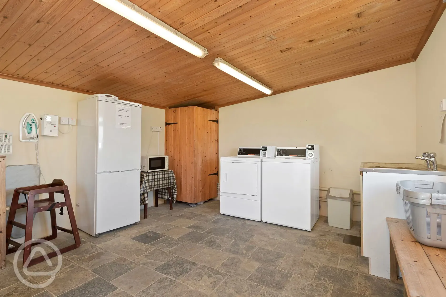 Communal room with laundry, washing up sinks and a fridge