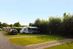 Electric partial hardstanding touring pitches with hardstand strips and grass