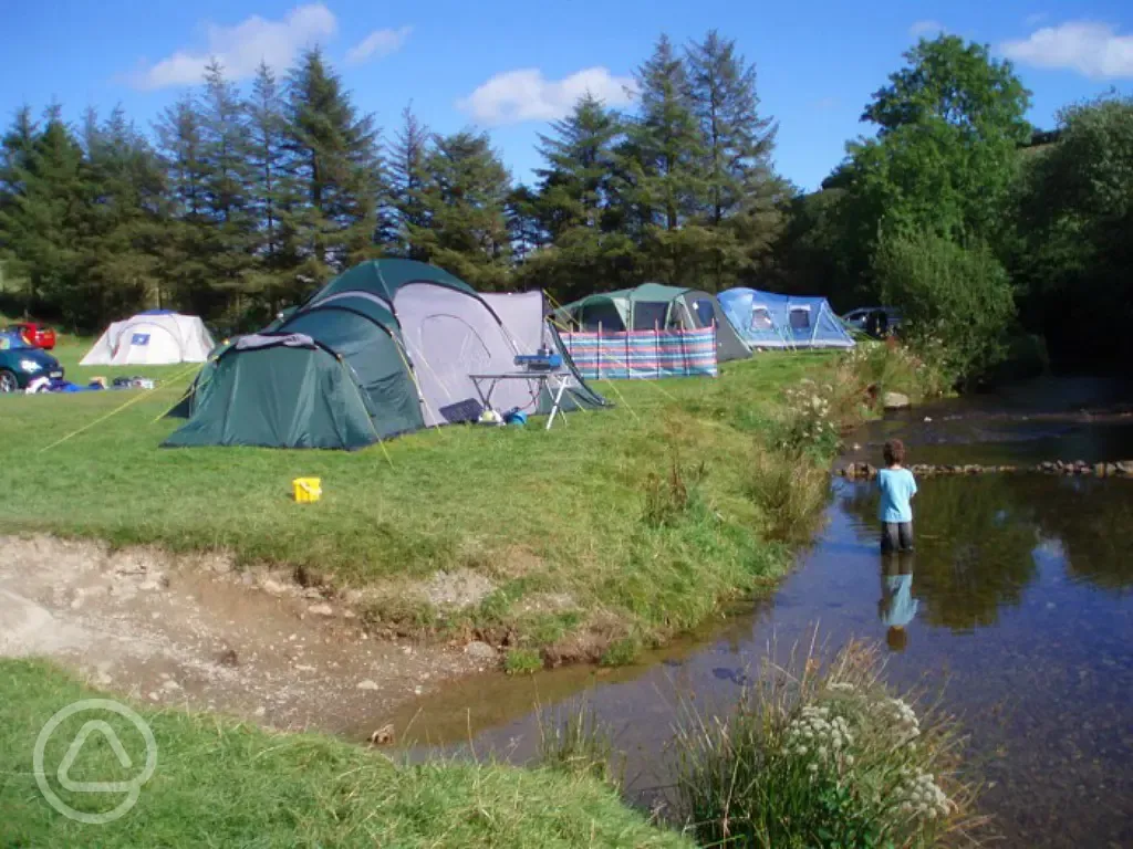 Child playing in the river at the campsite