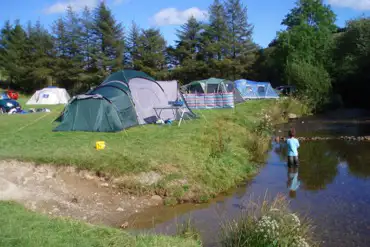 Child playing in the river at the campsite