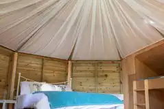 Glamping cabin interior with a double bed and two single bunk beds