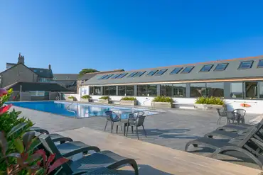 Outdoor swimming pool with pool chairs at Polmanter Touring Park
