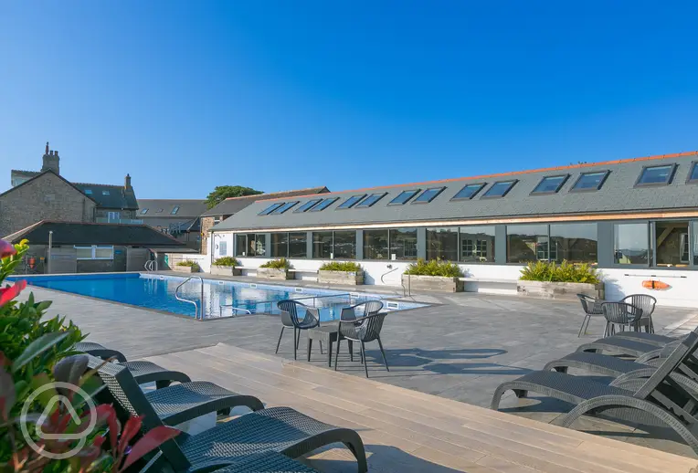 Outdoor swimming pool with pool chairs at Polmanter Touring Park