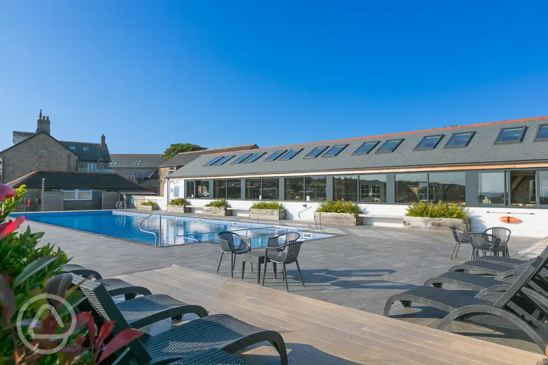 Outdoor swimming pool with pool chairs at Polmanter Touring Park