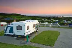 Fully serviced hardstanding pitches overlooking the coast at sunset