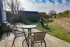 Shepherd's hut deck with a walled garden and seating Shepherd's hut deck with a walled garden and seating