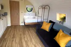 Luxury glamping pod interior with a double bed and double sofa bed Luxury glamping pod interior with a double bed and double sofa bed