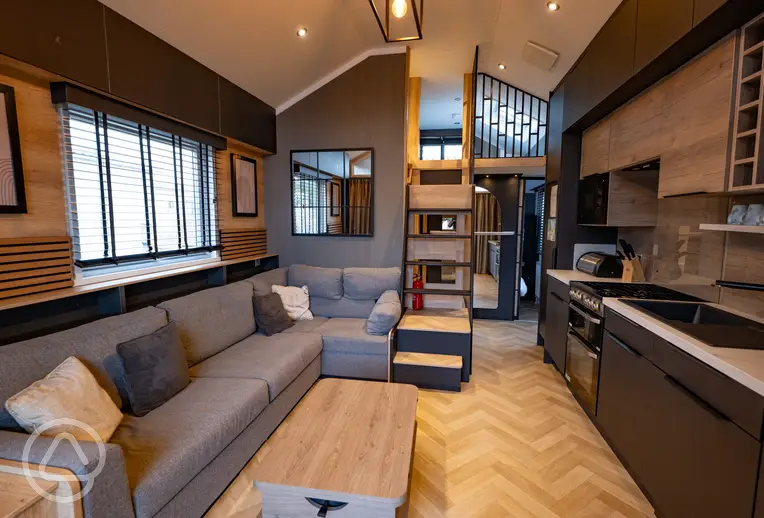 S-pod with a sofa, mezzanine level, kitchen and bedroom to the rear