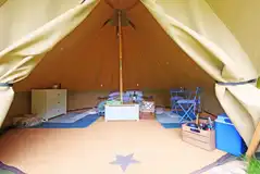 Bell tent interior with a double bed (including bedding)