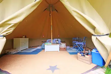 Bell tent interior with a double bed (including bedding)