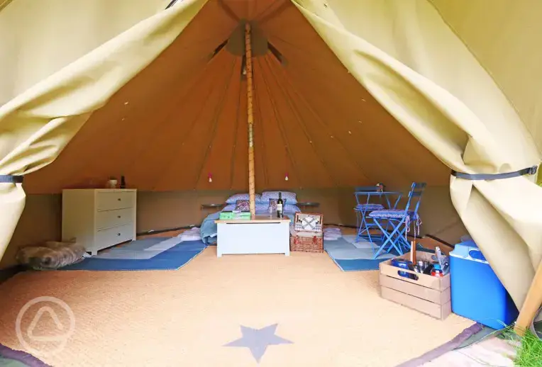Bell tent interior with a double bed (including bedding)