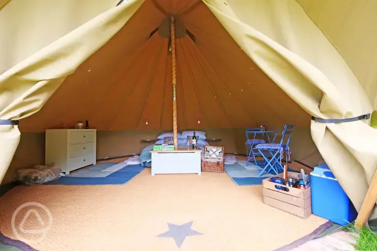 Bell tent interior with a double bed (including bedding)