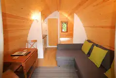 Ensuite glamping pod interior with a double bed and double sofa bed