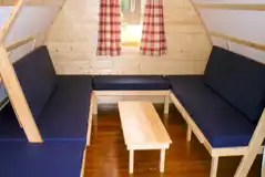 Wooden camping pod beds with memory foam mattresses that become seating