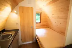 Ensuite pod bed and kitchen with a fridge, kitchen sink, kettle, microwave