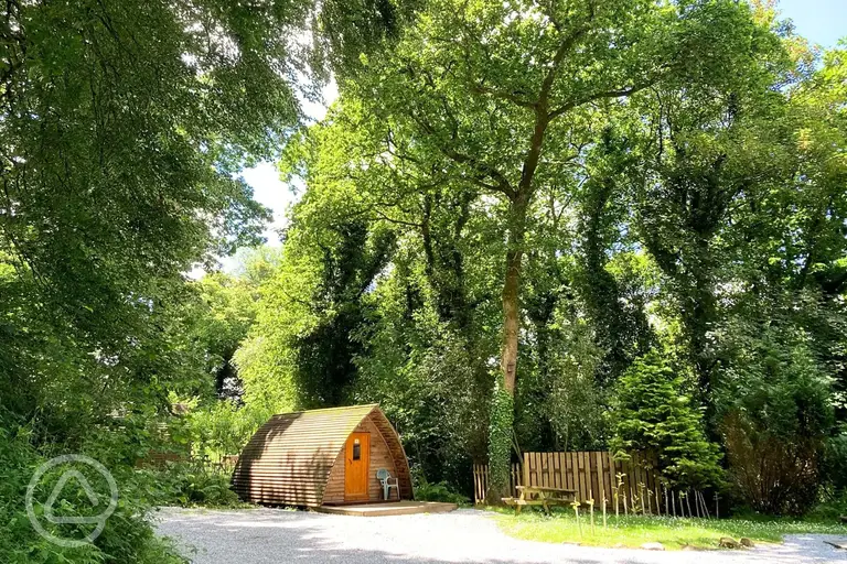 Camping pod with an outdoor picnic bench in the woodland area