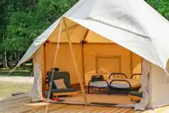 Furnished bell tent with a double bed and two single futons (no bedding)