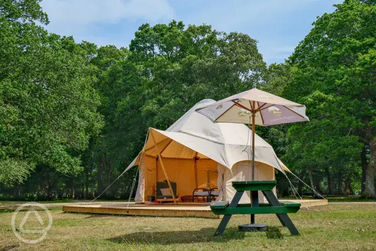 Furnished bell tent on a raised platform with a picnic bench