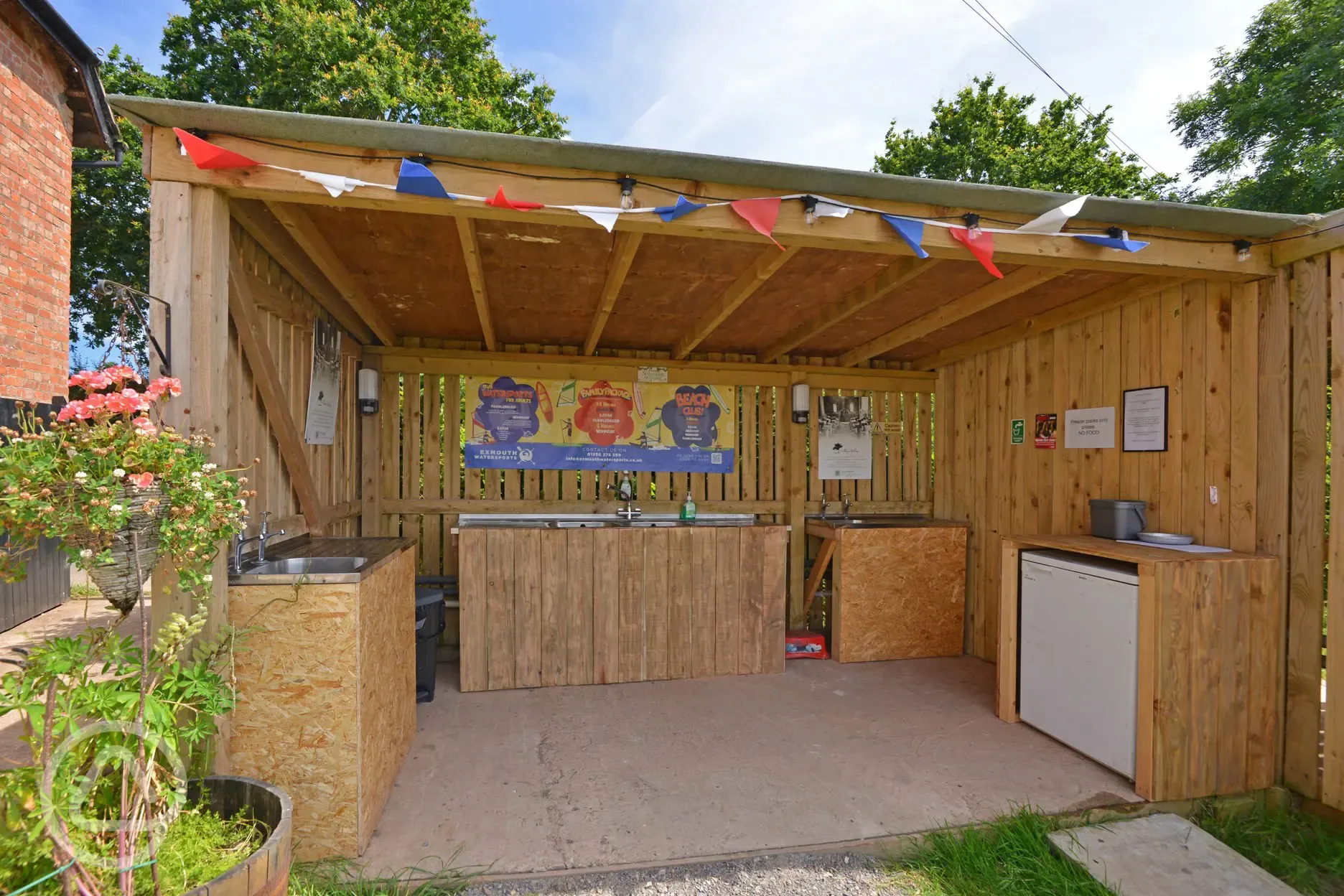 Outdoor, sheltered washing up area with a freezer for ice packs