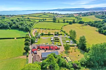 Aerial view of Prattshayes Campsite with the countryside and Devon coast behind