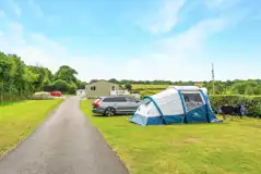 Electric grass tent pitches with space for a parked car