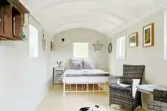 Shepherd's hut with a double bed and seating area