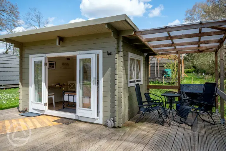 Lodge pods with a covered deck area and furniture