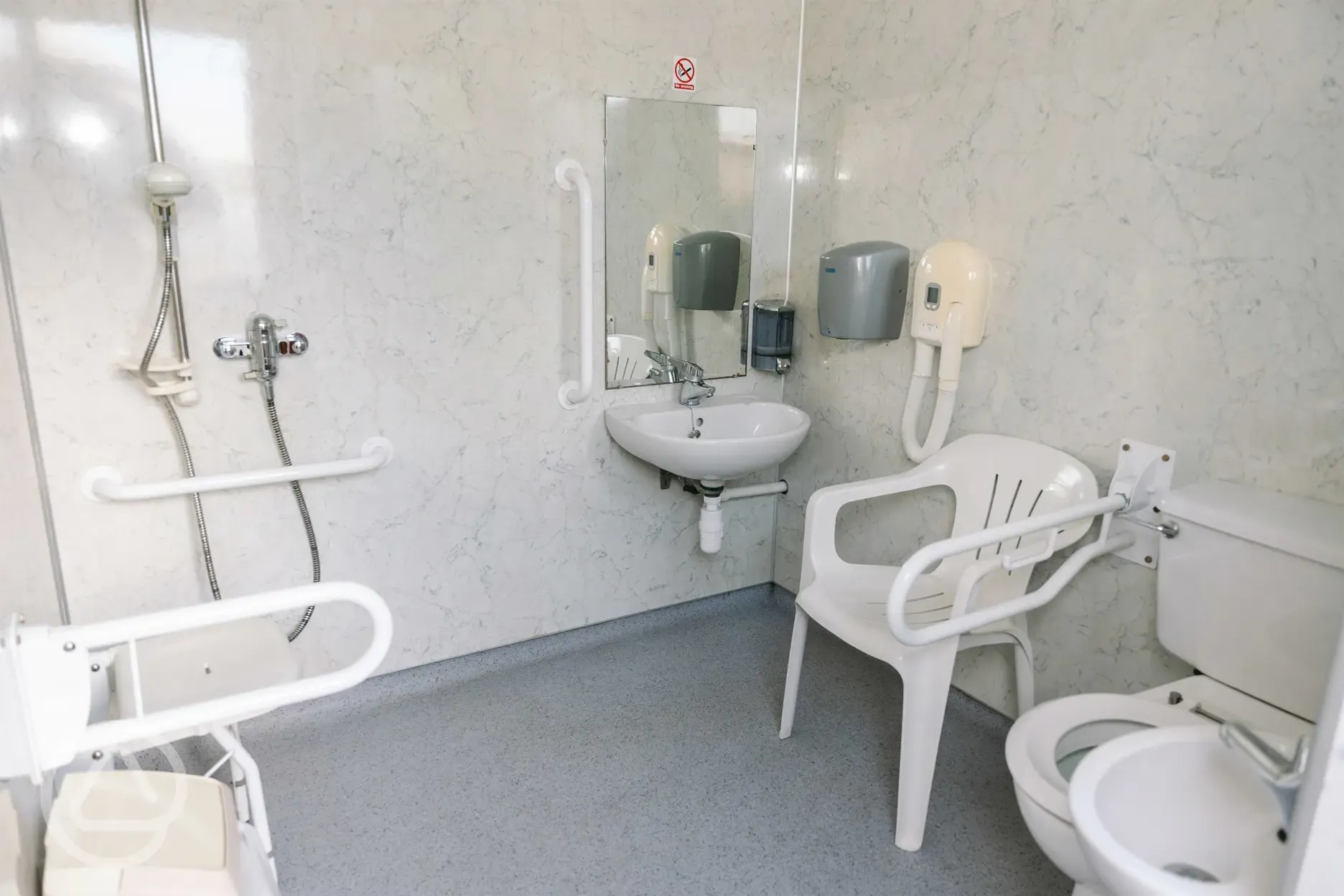 Accessible facilities with toilet, shower, sink, handrails and seating