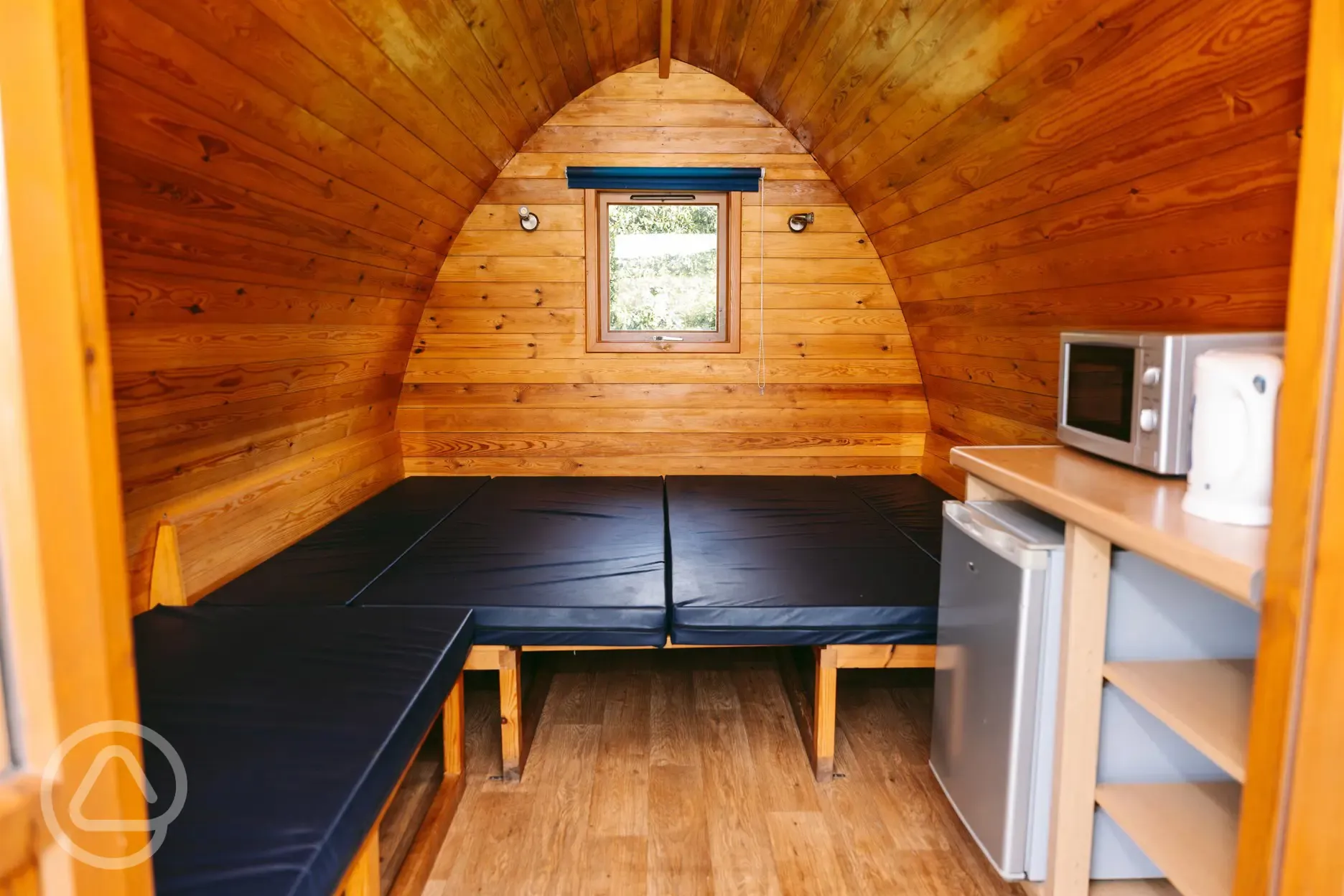 Camping pod interior with microwave, kettle and fridge