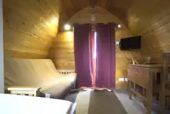 Mega glamping pod with a sofa bed, table, chairs and TV