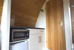 Mega glamping pod kitchen with a fridge, a microwave and kettle 