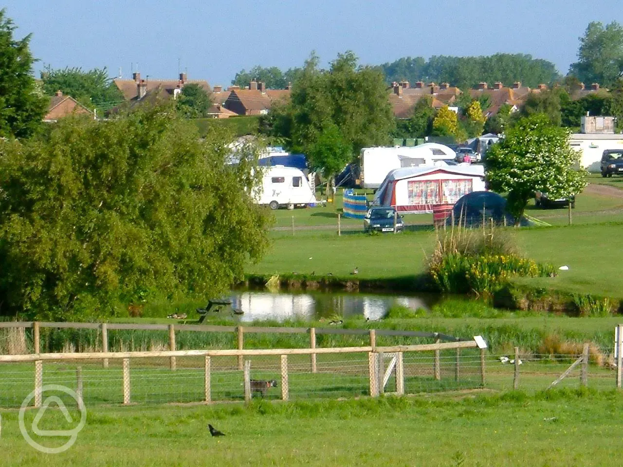 Grass pitches by Fairfields Farm lake