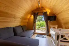 Mega pod interior with a futon sofa, TV, and dining area Mega pod interior with a futon sofa, TV, and dining area