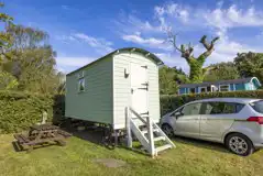 Green shepherd's hut with outdoor picnic bench