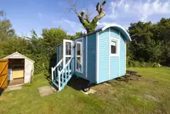 Blue shepherd's hut with shared facilities nearby
