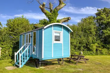 Blue shepherd's hut, sleeping two with a double bed, kitchen and electricity