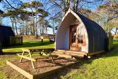 Wooden camping pods with a private picnic bench