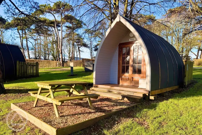 Wooden camping pods with a private picnic bench
