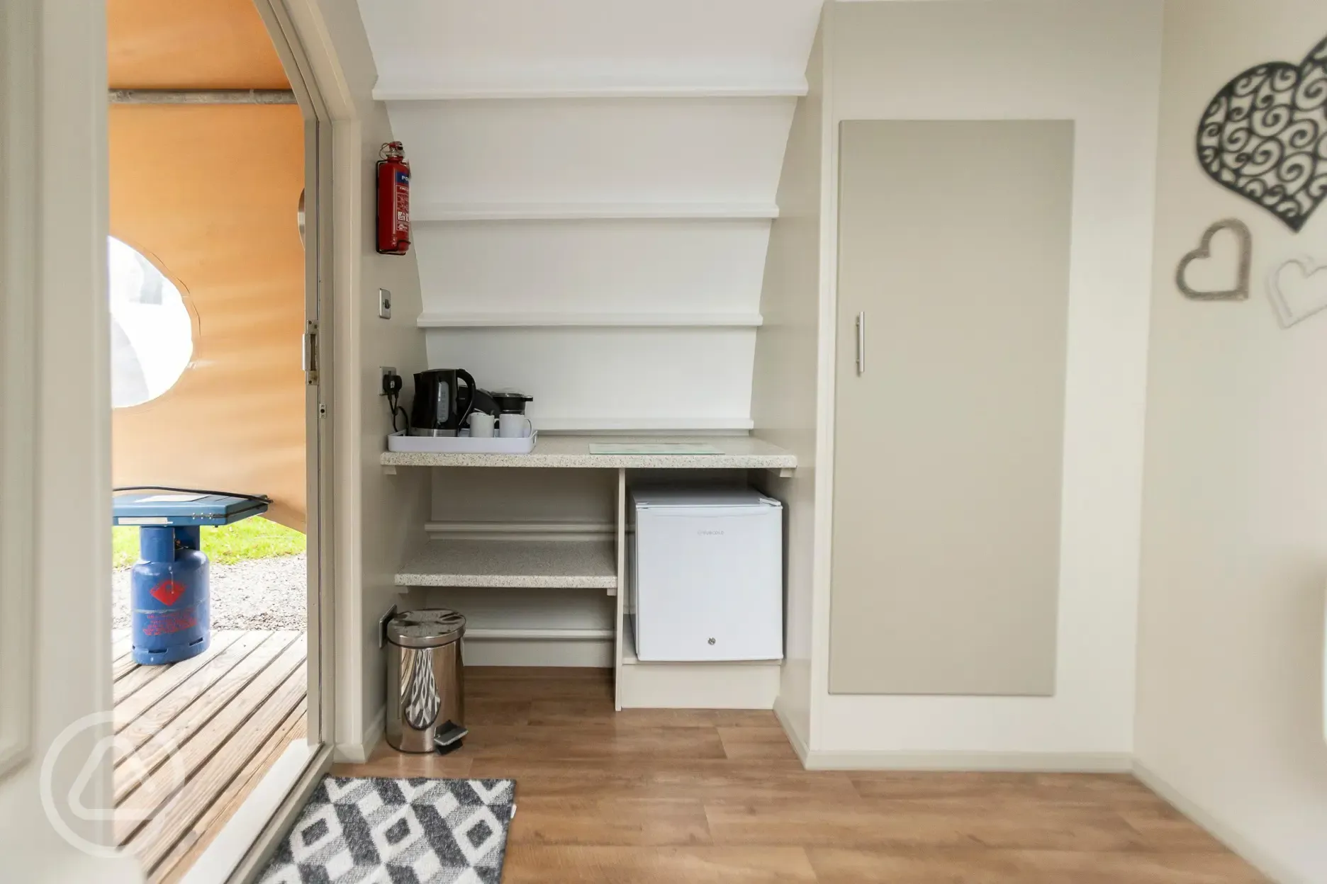Glamping cabin interior with kitchenette, fridge and kettle